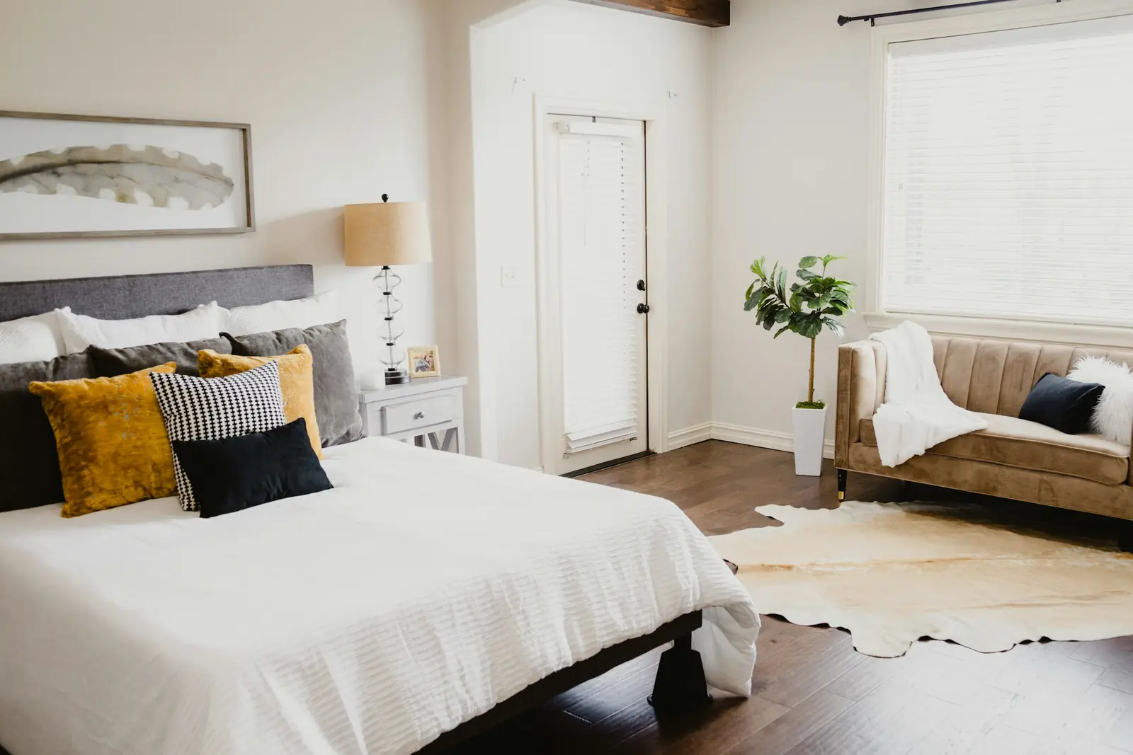Bright bedroom with a made bed and plants